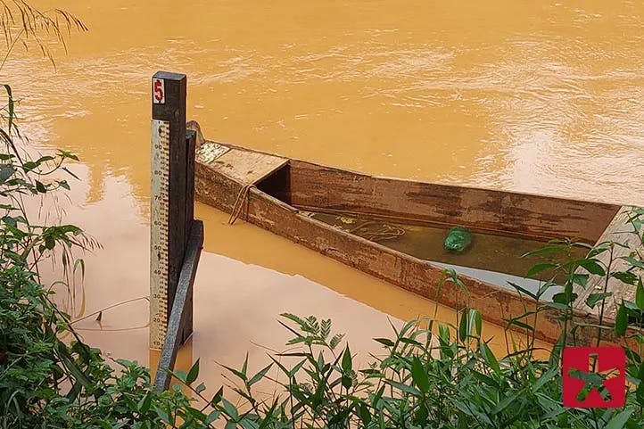 imagem colorida, mostrando um barco no Rio Paranaíba, ao lado da régua de medição do volume de água