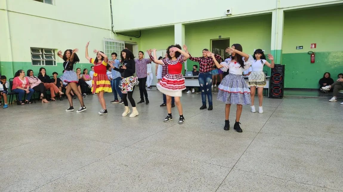 imagem colorida mostrando alunos da Escola Zama Maciel de pé no pátio da instituição durante festival de dança