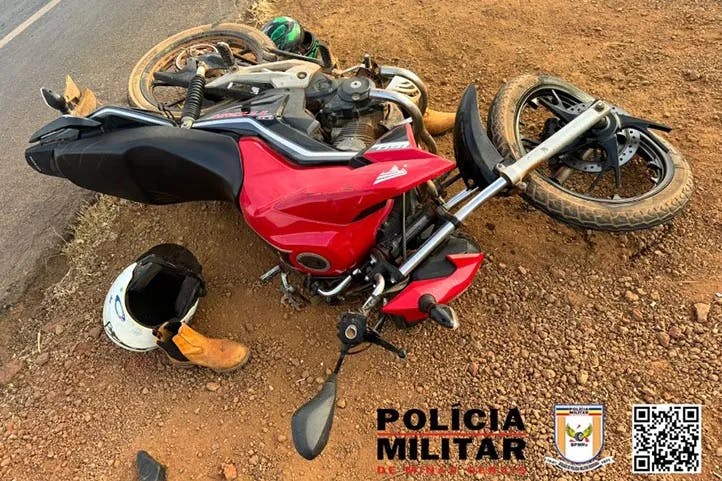  Imagem colorida mostrando motocicleta vermelha caida ao chão, com estragos na roda dianteira e frente do veículo. Ao lado um capacete e uma bota.