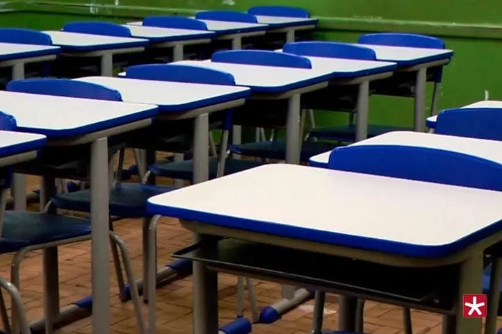 cadeiras e mesas dentre da sala de aula