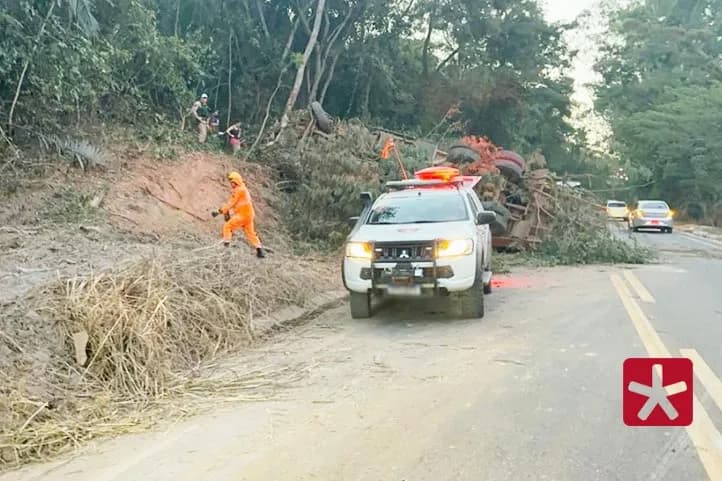 imagem colorida mostrando viatura do corpo de bombeiros a frente do caminhão tombado na rodovia